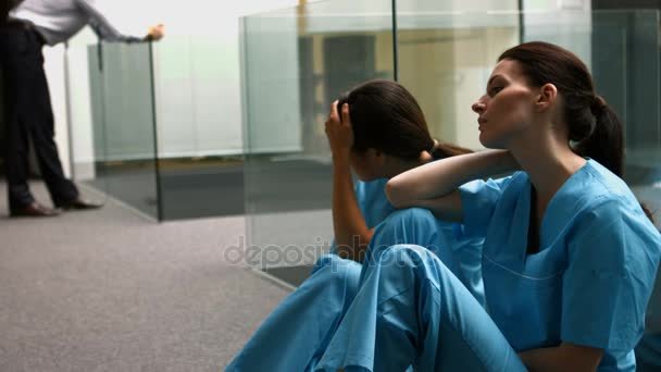 depositphotos 132417086 stock video sad nurses sitting on corridor